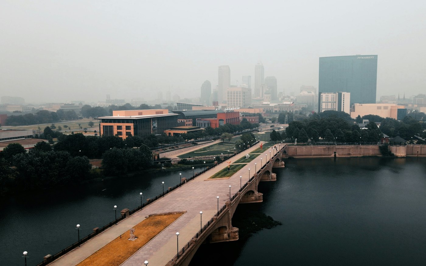 A bridge over a river with the Indianapolis skyline behind it