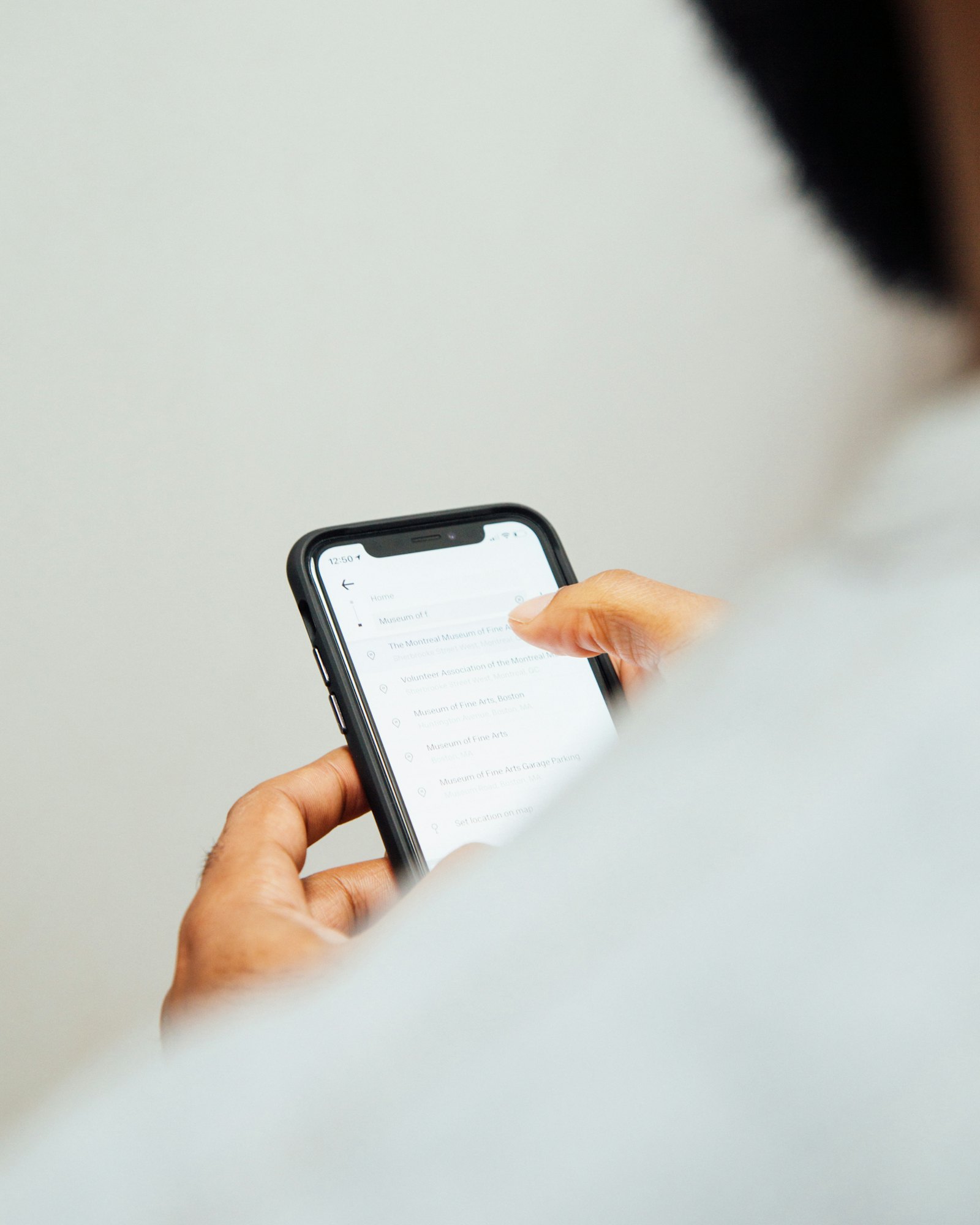 A man in a white top holding a phone