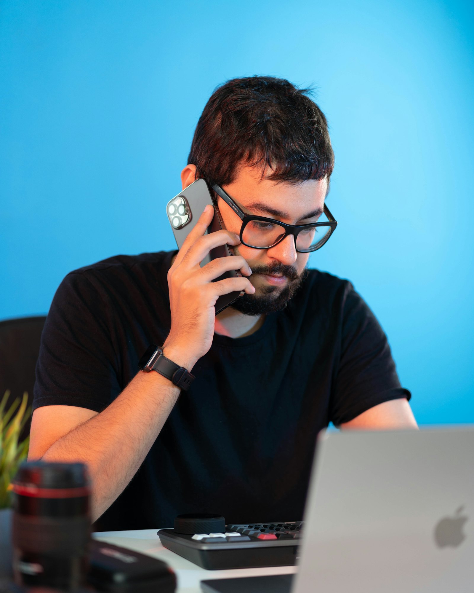 A man at a desk talking on his phone