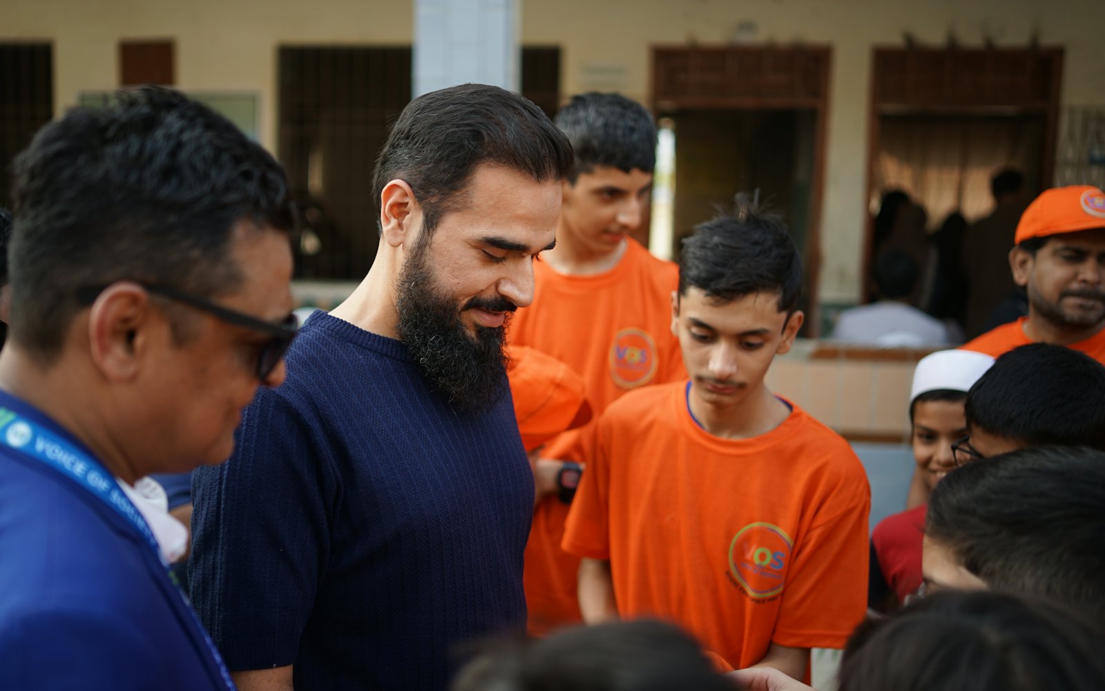 A group of people, some in orange shirts, gathered together