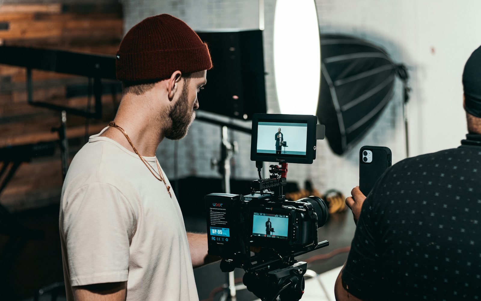 A videographer checking the monitor on a camera rig during a studio shoot