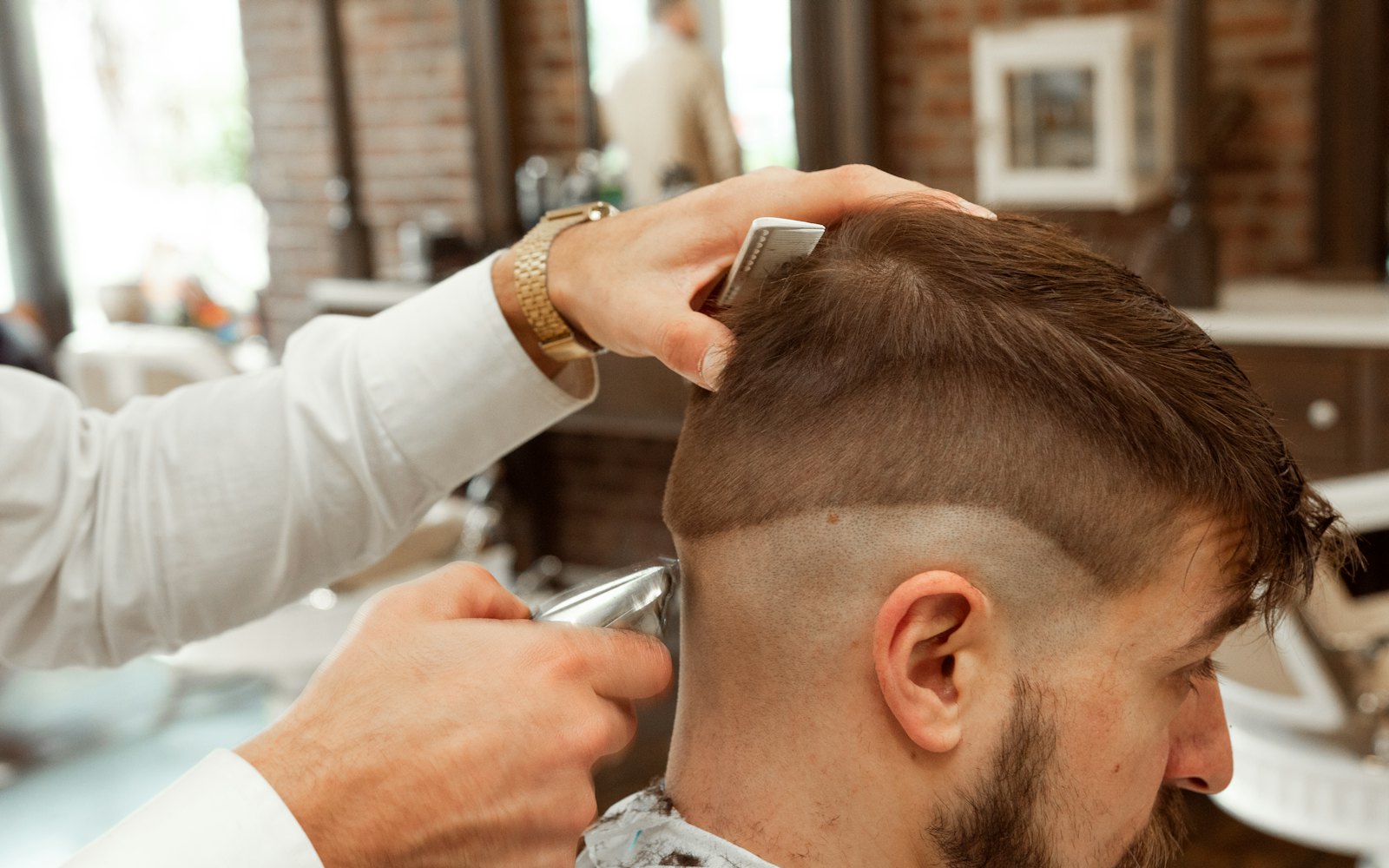 A barber cutting a client&rsquo;s hair