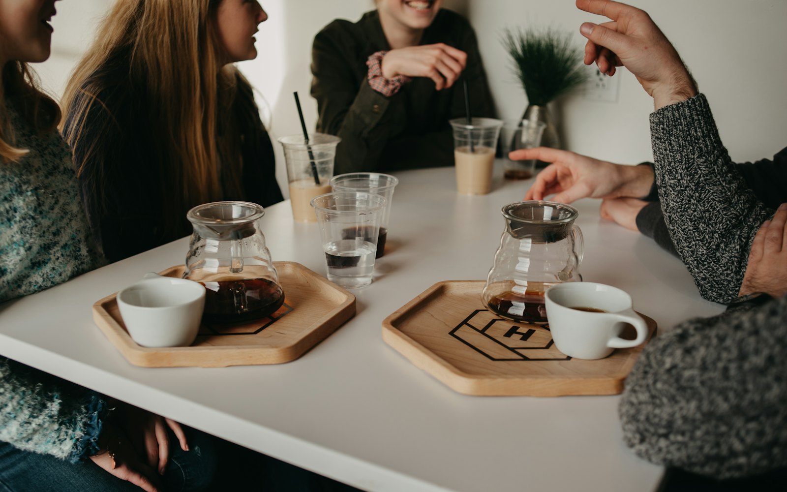 A group of people talking over coffee at a white table
