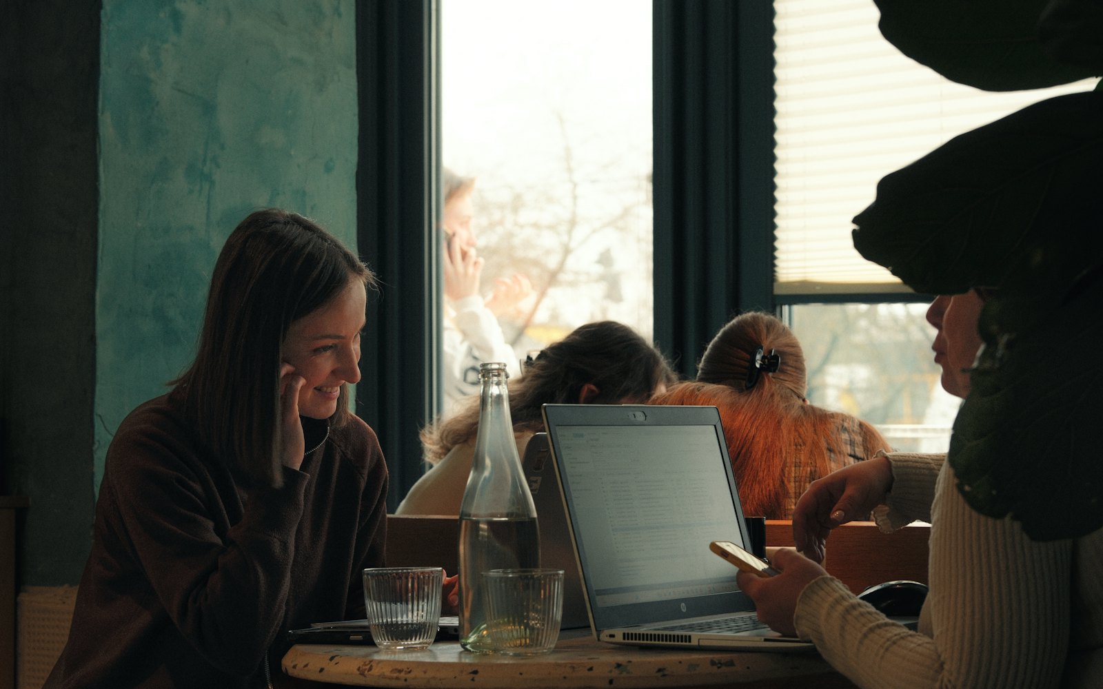 Two women talking at a table with a laptop