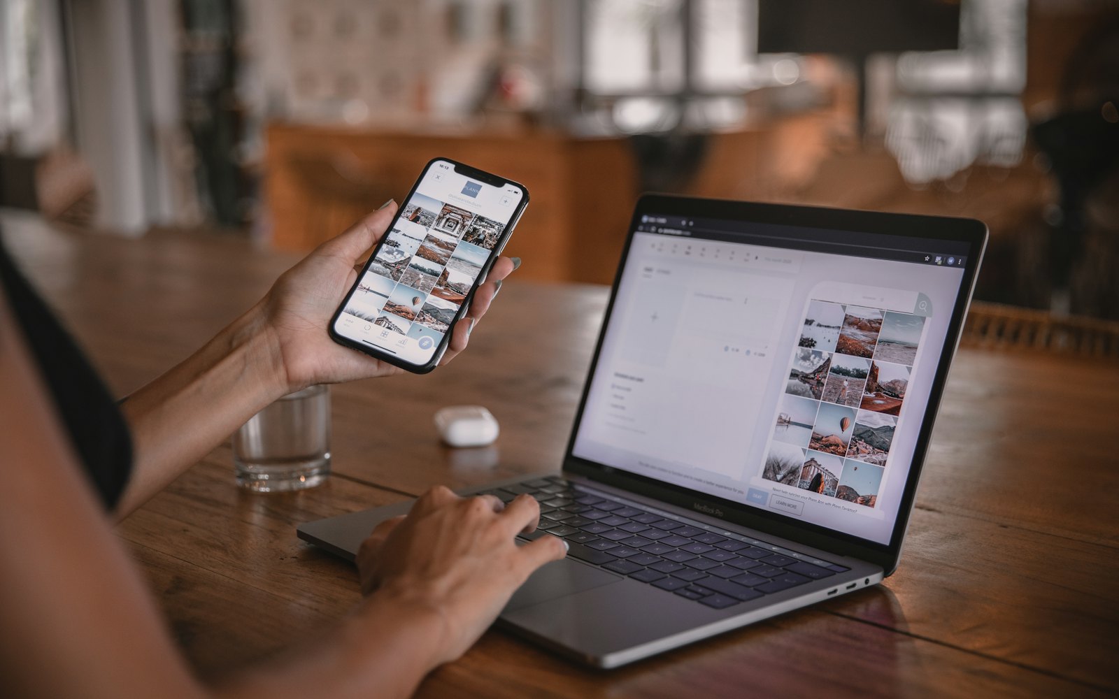 A woman at a desk with a laptop and an iPhone