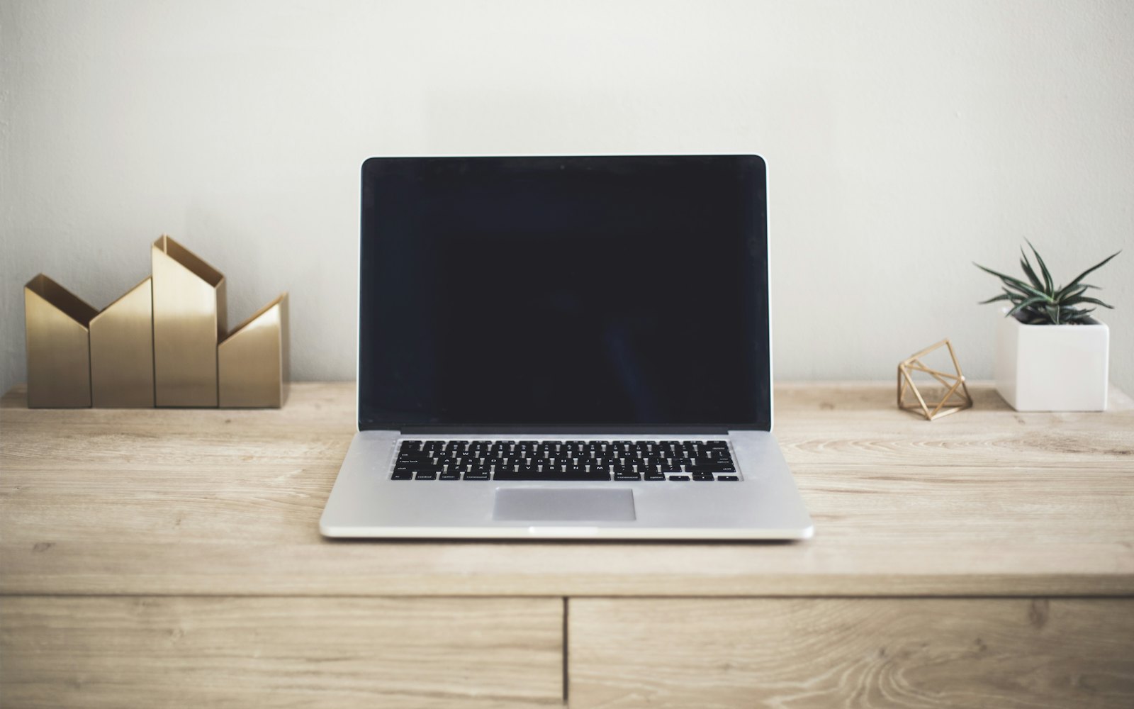 A laptop open on a brown wooden table